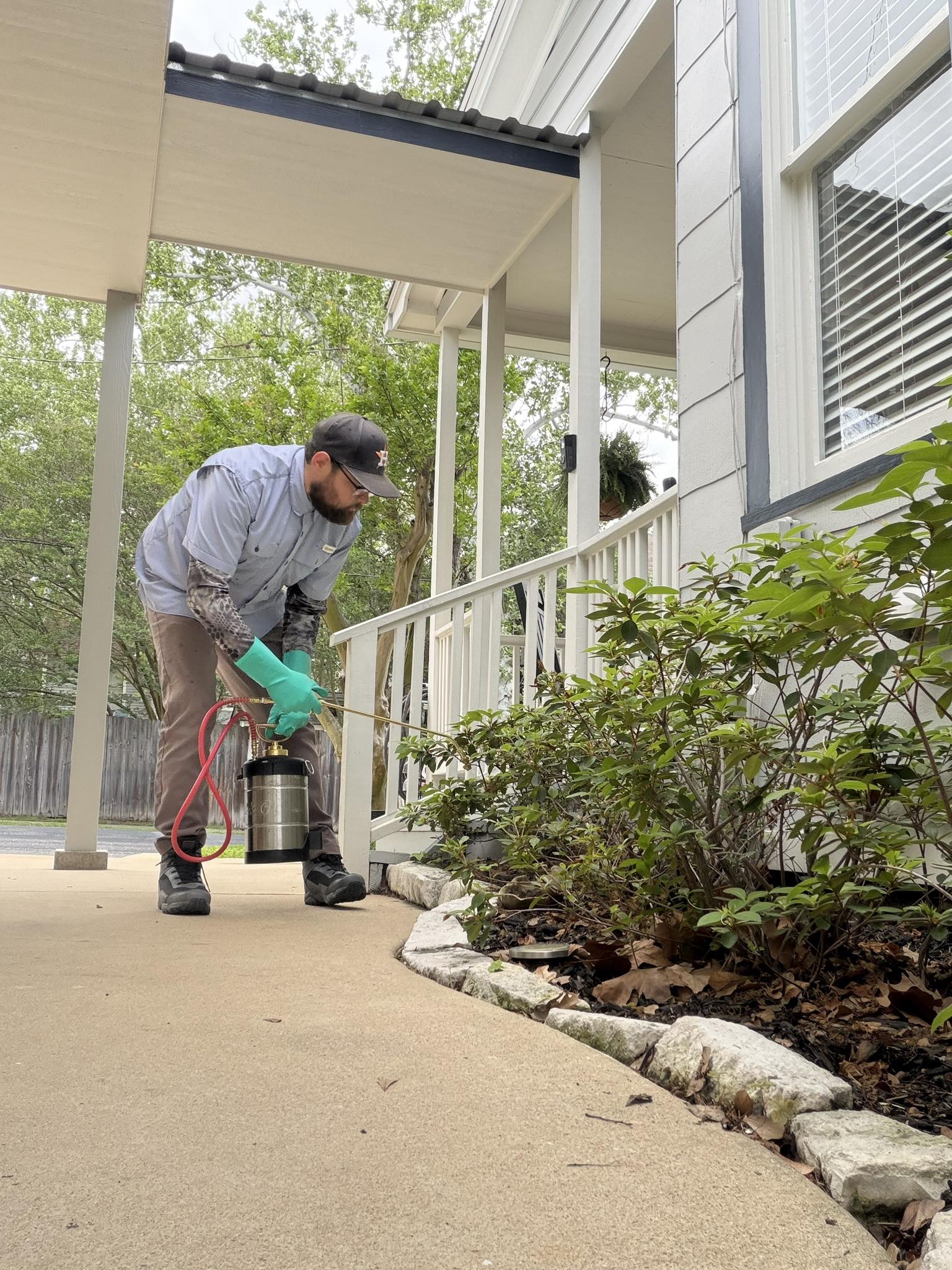 Pest control technician treating a home in Brenham TX